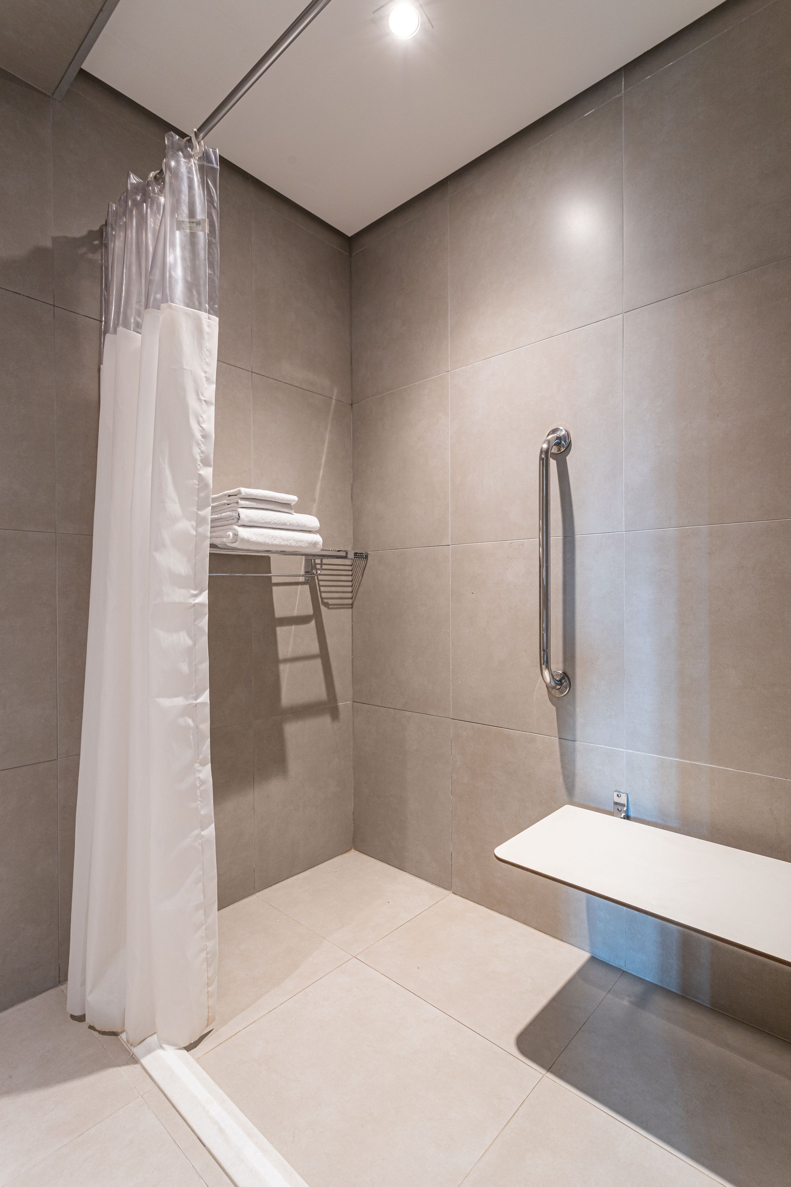 A modern bathroom with a shower, a toilet, and a sink.