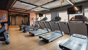 A gym with treadmills, ellipticals, and a stationary bike. - Charlie Alphaville  (Barueri)