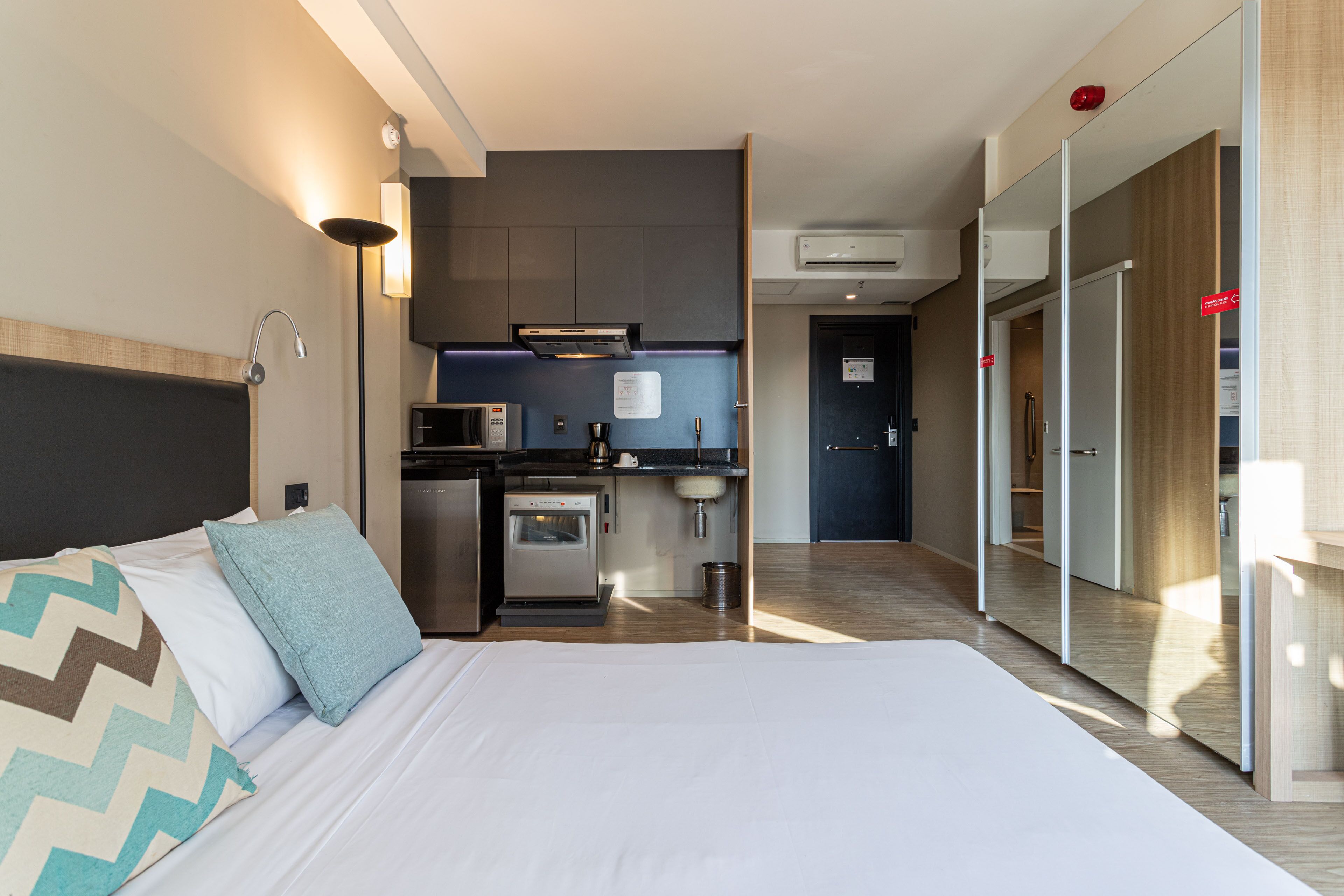Et moderne hotelværelse med seng, tekøkken og badeværelse.