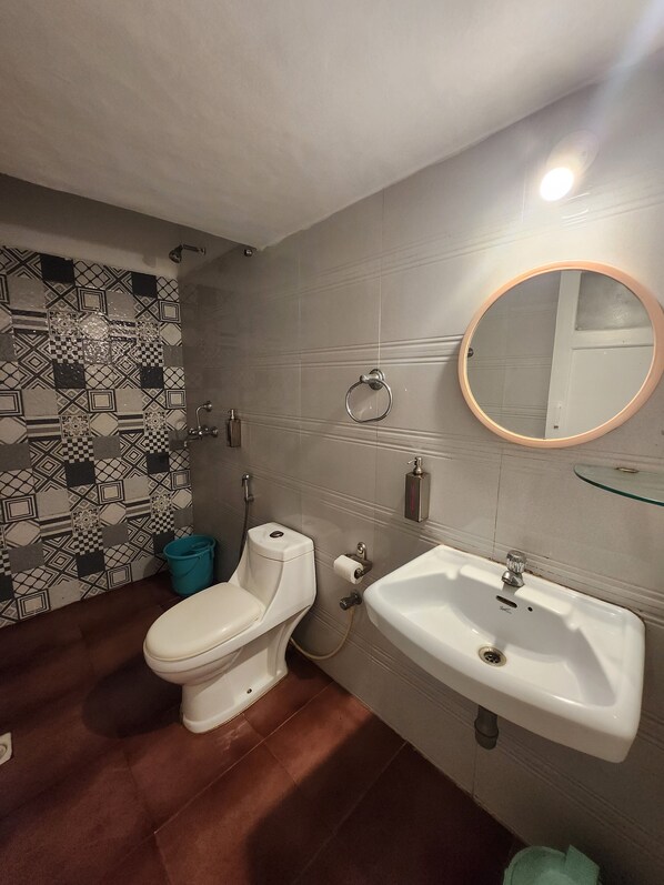 A bathroom with a toilet, sink, and a mirror.