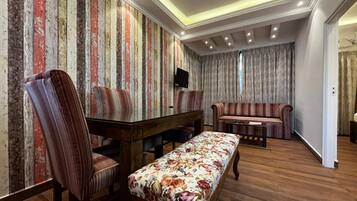 Habitación de lujo, vistas a la piscina | Zona de estar | Televisión LCD de 32 pulgadas con canales por satélite, una televisión