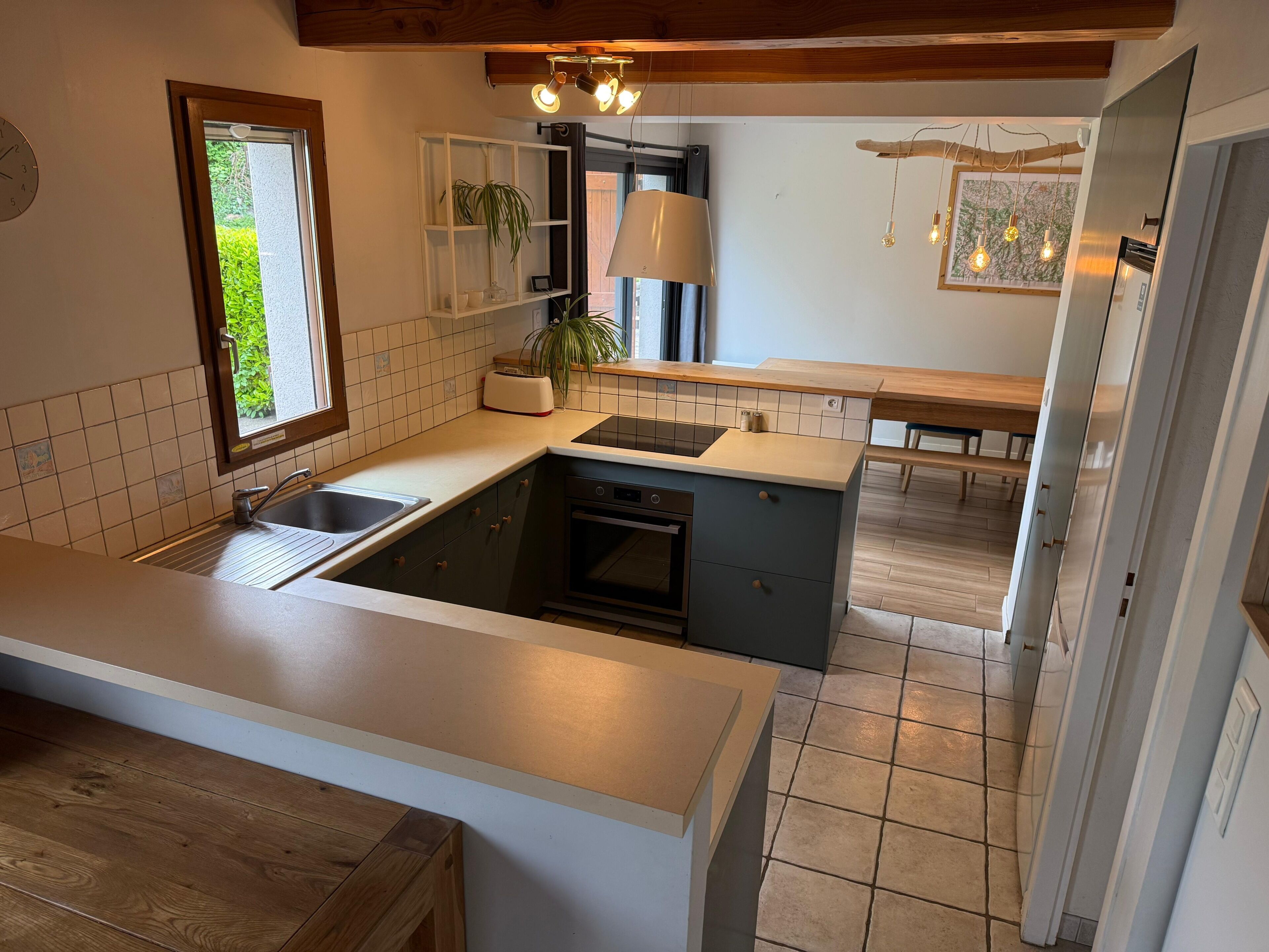 A modern kitchen with a built-in stove, a sink, and a window.