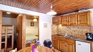 Eine kleine Küche mit Holzausstattung, einer Spüle und einem Kühlschrank.