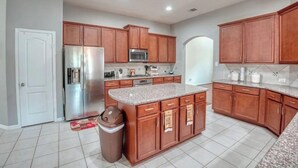 A modern kitchen with wooden cabinets, stainless steel appliances, and a granite countertop. - Luxury rental in great location (Spring)