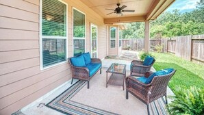 A covered patio with wicker furniture, a ceiling fan, and a view of the backyard. - Luxury rental in great location (Spring)