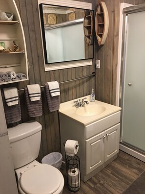 Een douche, handdoeken, zeep, toiletpapier