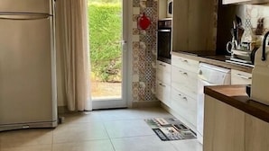 Una cocina con refrigerador, armarios y un salpicadero de azulejos.