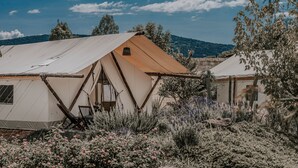 A tented accommodation with a view of the surrounding landscape, including hills and trees. - Salterra Glamping (Tequisquiapan)