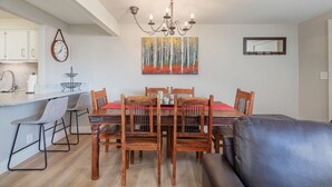 A dining area with a wooden table, chairs, and a chandelier. - Gros Ventre B7: Newly remodeled, pristine condo in Teton Village (Teton Village)