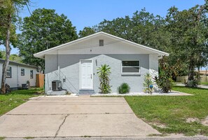 A single-story house with a front porch, a small attached garage, and a front yard with landscaping. - 2BR Apt, 5 Min to Busch Gardens | Unit A, Sleeps 6, Remodeled, Tampa (Tampa)