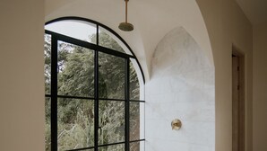 Een ruime kamer met een groot rondboogvenster, een betegelde vloer en een strak, elegant design.