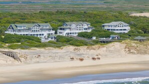 Ein großzügiges Anwesen direkt am Strand mit mehreren Häusern, einem Strand und Pferden.