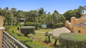 A resort with well-manicured gardens, palm trees, and a clear blue sky. - Apartment in Las Mimosas de Banús for 4 people | 22E (Puerto Banús - Marbella)