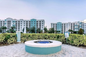 Un hotel con edifici a più piani, un elemento d'acqua circolare e un segnale che indica un'area per il fuoco.