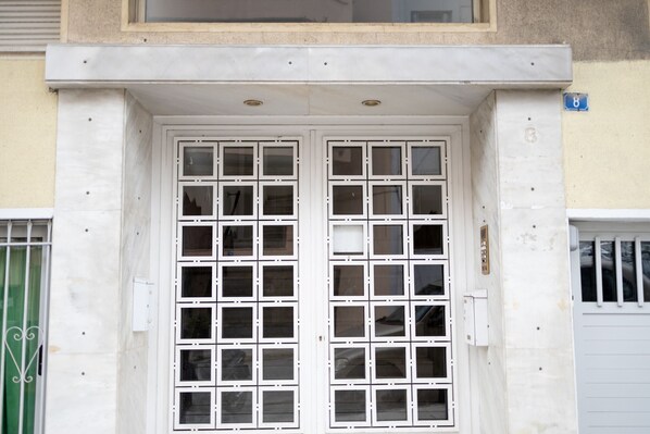 A building facade with a double door, multiple windows, and a small sign indicating the number 8.