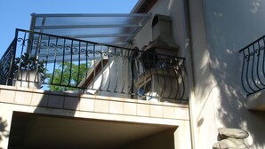 Ein Balkon mit Metallgeländer und einer weißen Markise.