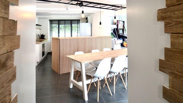A modern kitchen with a central island, white chairs, and a wooden dining table. - Charming holiday home - 10 min from Durbuy (Durbuy)