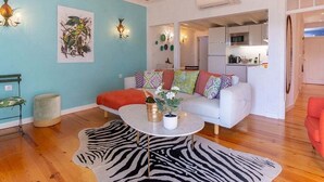 A living room with a white sofa, a zebra-patterned rug, and a small coffee table.