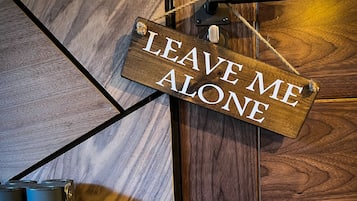 Une porte en bois sur laquelle est accrochée une pancarte portant l’inscription « NE ME DÉRANGEZ PAS ».