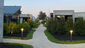 Camí que condueix a un edifici modern, amb un sender de grava i vegetació cuidada.