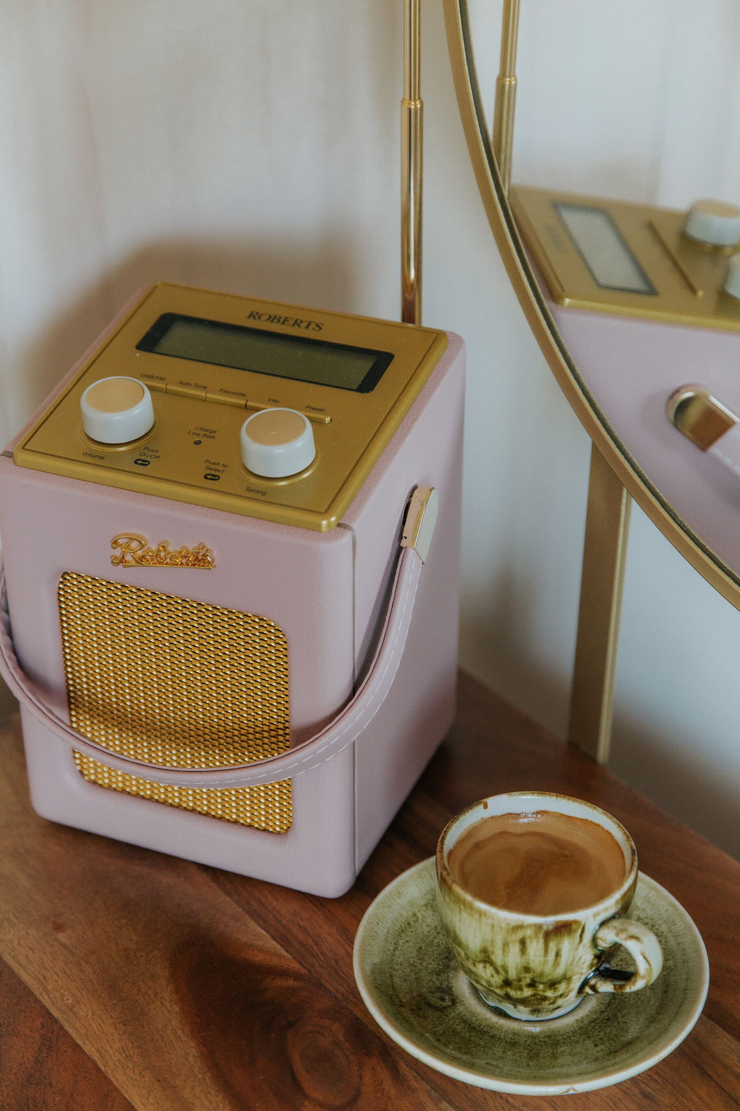 Ein altes Radio und eine Tasse Kaffee auf einem Holztisch.