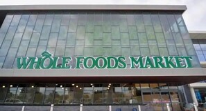 Experience the vibrant atmosphere of this Whole Foods Market, featuring a striking glass facade and prominent signage.