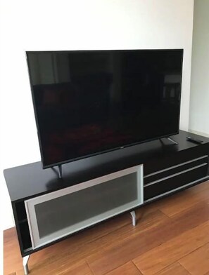 Entertainment unit features a flat-screen TV and a single drawer for storage.