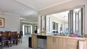 Une cuisine moderne dotée d’un grand îlot central, de meubles en bois et d’un lave-vaisselle.