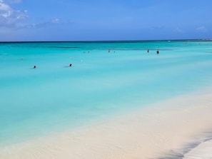 A beach with clear turquoise water and a sandy shore.