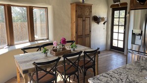 Un coin repas comprenant une table et des chaises en bois, un buffet et un réfrigérateur.