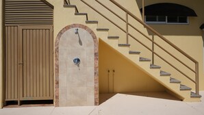 Una scala con corrimano che porta a una porta con maniglia in metallo.