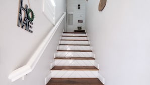 A staircase with white railings and wooden steps leading to a door.