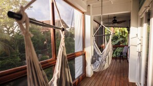 A wooden deck with two hammocks, a table, and chairs. - Gorgeous Entire Floor Condo - 3 BR Private Balcony & Rooftop Pool (West Bay)