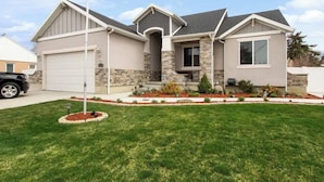 A two-story house with a garage, stone exterior, and a well-maintained lawn. - Sandy, UT home. Near the best skiing in the world (Sandy)