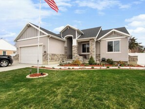 Stunning single-story home with a central entrance and well-manicured lawn.