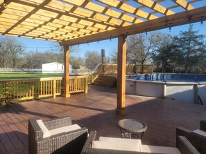 A wooden deck with outdoor furniture, a pool, and a pergola structure. - The Perfect Getaway (Elgin)