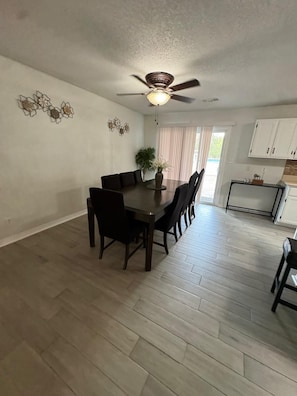 A dining area with a wooden table and chairs, a ceiling fan, and a view of the outdoors through a window. - The Perfect Getaway (Elgin)