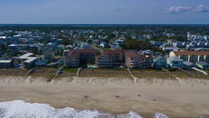 Vista aérea de una zona residencial costera con propiedades frente a la playa y una playa de arena.