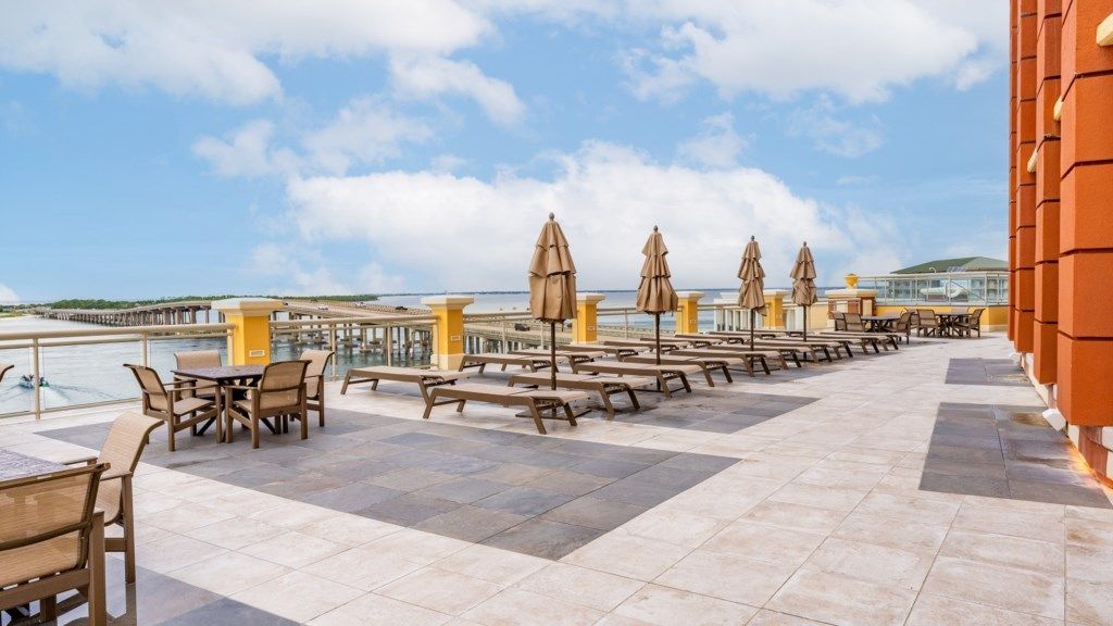 A terrace with outdoor seating and a view of the sea.