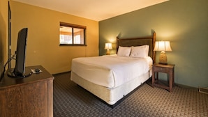 A hotel room with a bed, bedside lamps, a desk with a computer, and a window. - Wisconsin Dells | Pool & Waterpark Access | 2BR Villa (Wisonsin Dells)