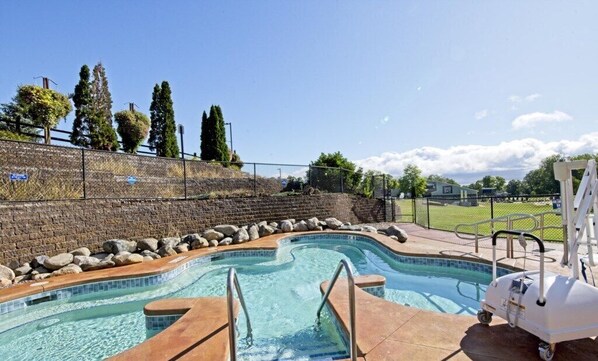 Relax by the pool surrounded by lush greenery and a serene atmosphere.