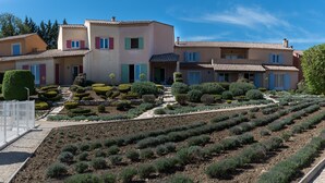 Edificio residencial con jardín que presenta hileras de lavanda y arbustos podados.