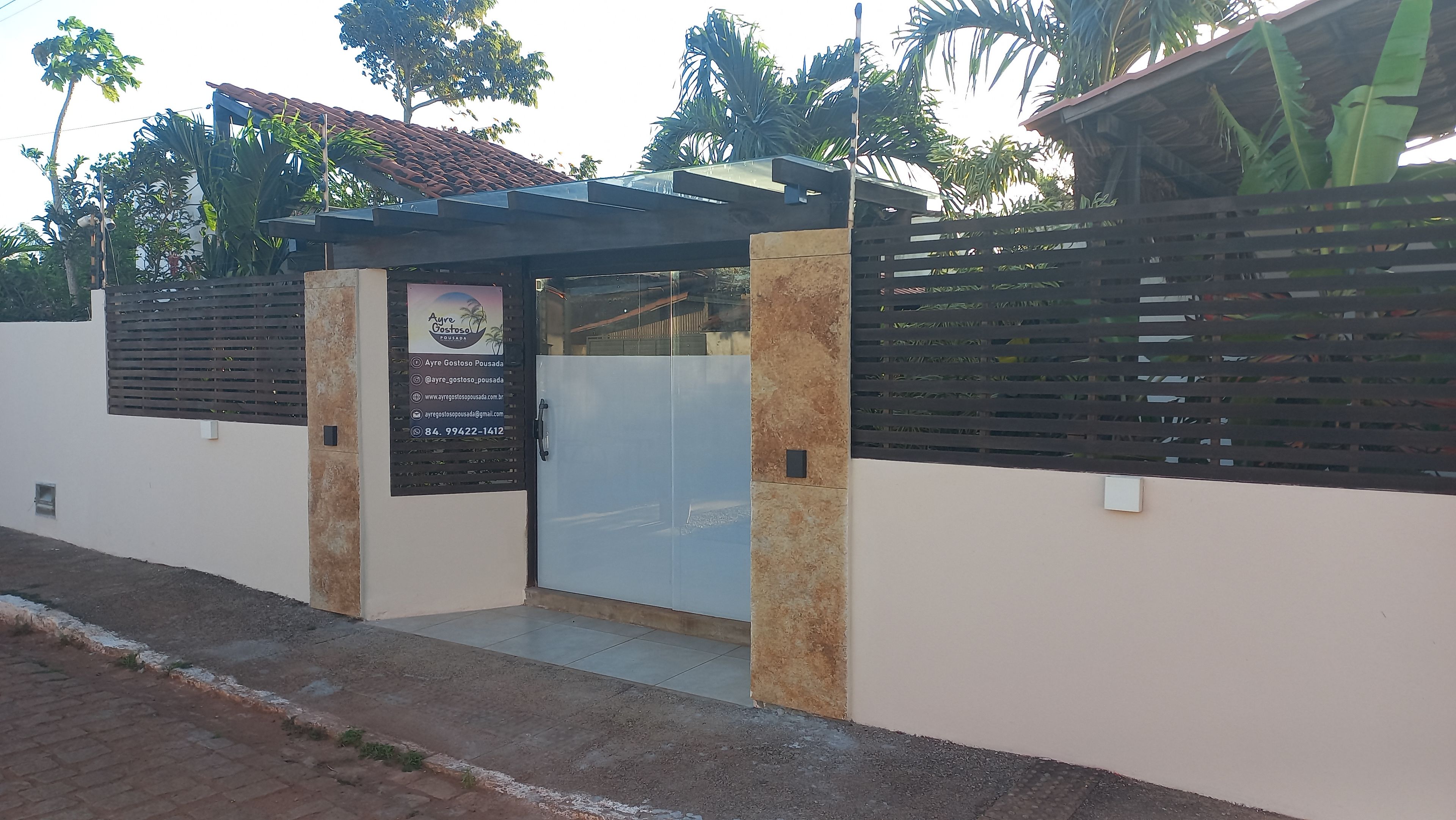A gated entrance with a metal gate and a signboard.