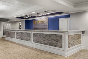Ein Empfangstresen mit blauer Akzentwand, einem Schild mit der Aufschrift 'WYNDHAM VACATION RESORTS' und einer Wandverkleidung mit Steinoptik.
