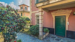 A building with a stone pathway, a green door, and a balcony with a wrought iron railing. - CASA FLAMINIA - Panorama, Relaxation, and Parking (Ruta)
