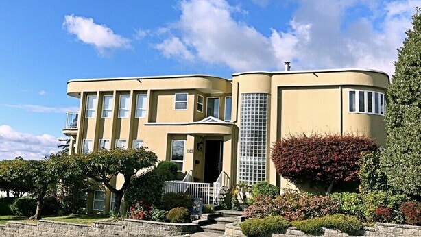 Un bâtiment à deux étages doté d’une façade incurvée, d’une entrée centrale et d’un petit porche.