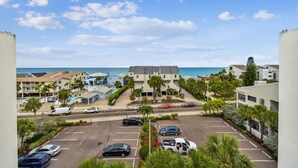 A coastal hotel with a parking lot, multiple buildings, and a view of the ocean. - Waterfront views - steps from the Beach! (Indian Shores)