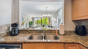 A kitchen with granite countertops, stainless steel appliances, and wooden cabinets. - Waterfront views - steps from the Beach! (Indian Shores)