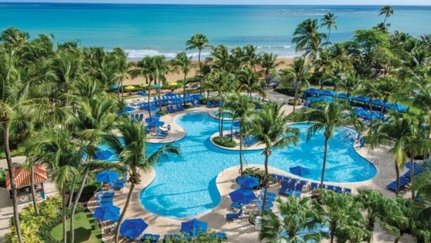 A resort with a large pool, palm trees, and a beach view. - Rio Mar Puerto Rico | Caribbean Family Getaway | Pool & Beach | 3BR Sleeps 10 (Rio Grande)