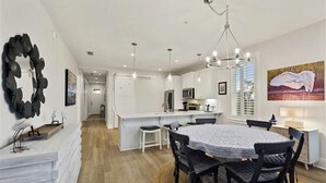 A modern kitchen with white cabinets, a central island, and pendant lighting. - Moorings 31 - Sunset Spectacular<br>The Moorings at Jekyll Harbor Marina (Jekyll Island)